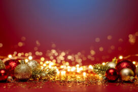 Red Christmas Background with Shiny Gold Ornaments and Christmas Tree Branches