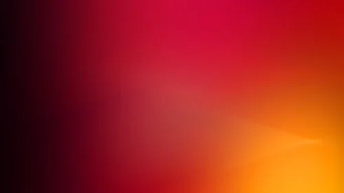 Dark red gradient background for PowerPoint fading from black on the left through crimson to an amber glow in the lower right
