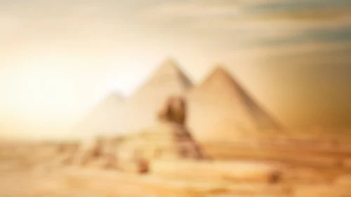 Egypt pyramids background for PowerPoint with the Giza pyramids and Sphinx blurred in a golden beige desert haze